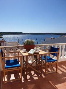 a table and chairs on a balcony with a view of the water at F98. Vistas al mar en Fornells! in Fornells
