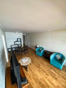 sala de estar con muebles azules y TV de pantalla plana en Departamentos Heimat 2, en La Serena