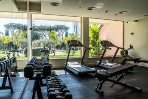a gym with several treadmills and elliptical machines at Hotel Isola Sacra Rome Airport in Fiumicino