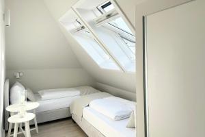 a small attic bedroom with two beds and a table at Techts Landhus Birkenallee in Timmendorfer Strand