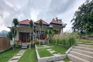 a house with palm trees in the yard at Onion Garden And Natural Hotspring in Kubupenlokan