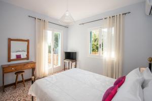 Un dormitorio con una cama, un espejo y ventanas. en Hidden Sea Crest Villa by "elite", en Lithakia
