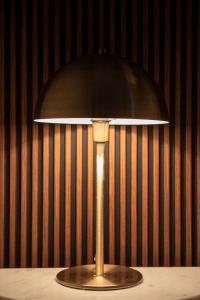 a lamp on a table in front of a wall at Havre de Paix, parking, wifi, draps et servilletes, tout inclus in Urrugne