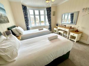 a hotel room with two beds and a desk at Sea View Three Bed Detached Home - With Parking - Next to Beach! in Bournemouth