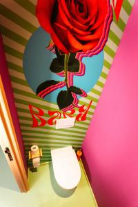 a bathroom with a rose painted on the wall at Capsule Flower - Balneo - Cinema - Billard - Nintendo Switch - Mons Centre in Mons +27 photos