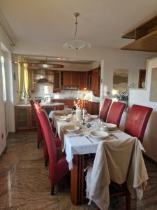 comedor con mesa y sillas rojas en House Olive Garden Strunjan, en Strunjan