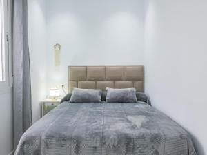 una camera da letto con un grande letto con copriletto grigio di Cubo's El Rincon del Caminito del Rey Apartment ad Ardales