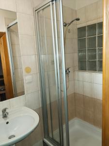 La salle de bains est pourvue d'une douche et d'un lavabo. dans l'établissement Apartmán se dvěma ložnicemi, à Zlín