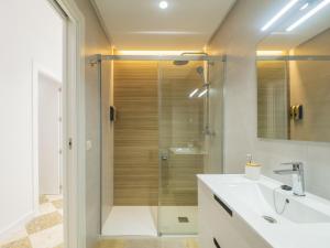 un bagno con doccia e lavandino bianco di Cubo's El Rincon del Caminito del Rey Apartment ad Ardales Altre 35 foto