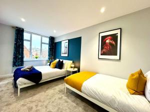 two beds in a room with blue and white at 3BR Westbourne Delight - Near Beach & Bournemouth! in Bournemouth
