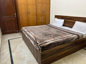 a bed in a room with a wooden frame at Hotel Royal Plaza B&B in New Delhi