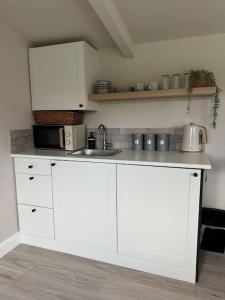 a kitchen with white cabinets and a sink at The Pod @ Essex House 