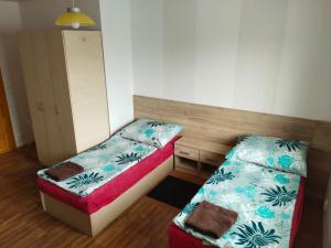 a small room with two beds and a cabinet at Apartmán se dvěma ložnicemi in Zlín