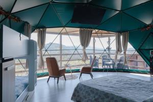 a room with a bed and chairs and a large window at La Cupola dei Trabocchi in Torino di Sangro +38 photos