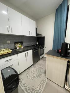 eine Küche mit weißen Schränken und einem schwarzen Herd in der Unterkunft Taksim Square 2plus1 Big Flat on the Center with 2 Bathroom in Istanbul
