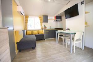 ein kleines Wohnzimmer mit einem Tisch und einem Sofa in der Unterkunft LunaBay Biograd Mobile Home in Biograd na Moru