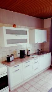 a kitchen with white cabinets and appliances on the counter at Monteurwohnungen in Aschersleben