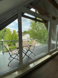 a balcony with a table and chairs and windows at Modernes Ferienhaus mit 2 Balkonen, Terrasse und Garten ! in Bochum