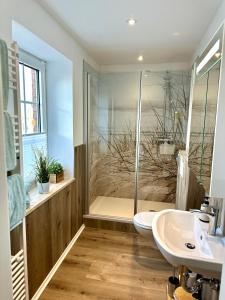 a bathroom with a shower and a toilet and a sink at Landhotel Bauernstuben in Neuharlingersiel