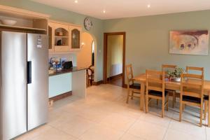 cocina y comedor con mesa y nevera en Spacious House in beautiful Malin Head, en Keenagh