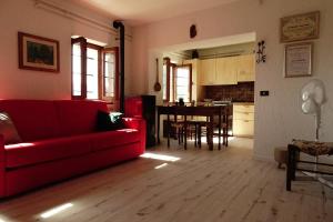 een woonkamer met een rode bank en een tafel bij La casetta di Elsa in Cesiomaggiore