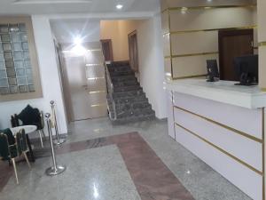 a room with a staircase with chairs and a table at Franzy Luxury Hotel & Suites in Jos