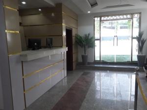 a lobby with a reception desk and a large window at Franzy Luxury Hotel & Suites in Jos