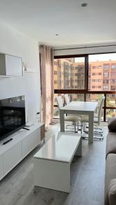 un soggiorno bianco con tavolo e divano di Madrid House Boutique , Aeropuerto , Ifema a Madrid