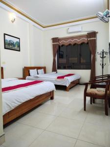 sypialnia z 2 łóżkami i krzesłem w obiekcie Hotel Cao Nguyên w mieście Dồng Văn