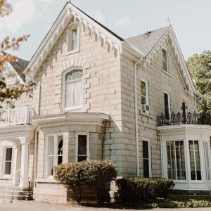 uma grande casa de tijolos brancos com um alpendre em Westover Inn em Saint Marys