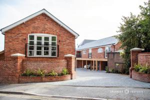 a red brick building with a large window at Stunning LUX Scandinavian style apt for 5 Parking - Keepers Cottage in Poole