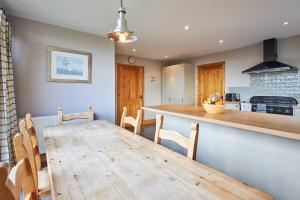 Una cocina y un comedor con mesa y sillas de madera. en Host & Stay - The Coach House, en Beal