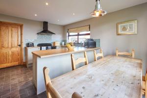 a kitchen with a wooden table and a dining room at Host & Stay - The Coach House in Beal