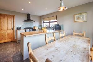 Una cocina con una mesa de madera y un comedor. en Host & Stay - The Coach House, en Beal