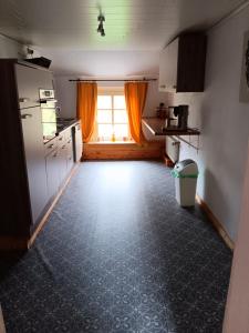 an empty kitchen with a window and a kitchen floor at Alte Pastorei Jennelt in Krummhörn