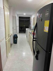 a kitchen with a refrigerator in the middle of a hallway at apartment in neiva goliat in Neiva