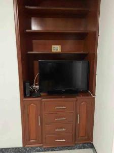 un centro de entretenimiento con TV en un armario de madera en apartment in neiva goliat, en Neiva