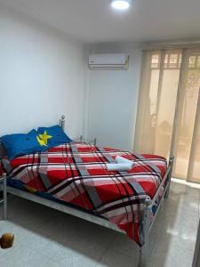 a bed with a red white and blue comforter in a room at apartment in neiva goliat in Neiva