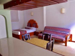 Habitación con 2 camas, mesa y sillas en Quinta Carrizalillo, en Puerto Escondido