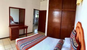 a bedroom with a bed and a desk and a mirror at Quinta Carrizalillo in Puerto Escondido