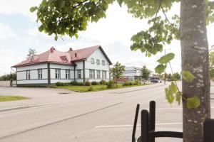 una casa blanca con techo rojo en una calle en Majoitus Wanhapankki, huoneisto B2 en Kalajoki