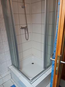 um chuveiro com uma caixa de vidro na casa de banho em Alte Pastorei Jennelt em Krummhörn