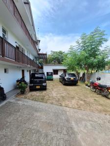 a couple of cars parked in front of a building at Baden Beach in Kalkudah