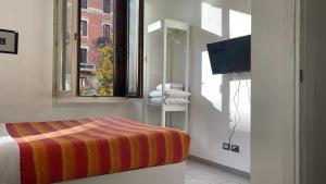 ミラノにあるSmart Central Apartments Doriaのベッドルーム(ベッド1台、窓、テレビ付)