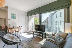 a living room with a couch and a tv at Comfortable studio with terrace in Antwerp in Antwerp