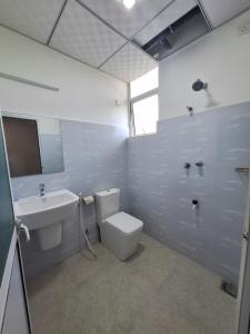 a bathroom with a white toilet and a sink at Baden Beach in Kalkudah