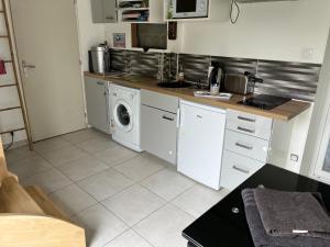 uma cozinha com uma máquina de lavar roupa e uma máquina de lavar roupa em STUDIO proche aéroport em Bouguenais