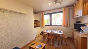 a small kitchen with a table and a window at St Christophe - 21B - Studio pied de piste - 4 per in Les Deux Alpes