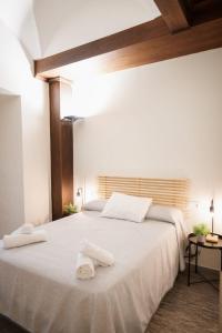a bedroom with a large white bed with towels on it at Apartamento Cuzco in Trujillo