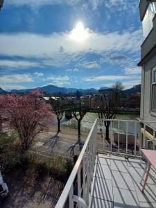 a balcony with a view of the water and trees at WOLKE, Apartment oder Doppelzimmer, Zentrum, am Fluss, Parkplatz in Bad Ischl